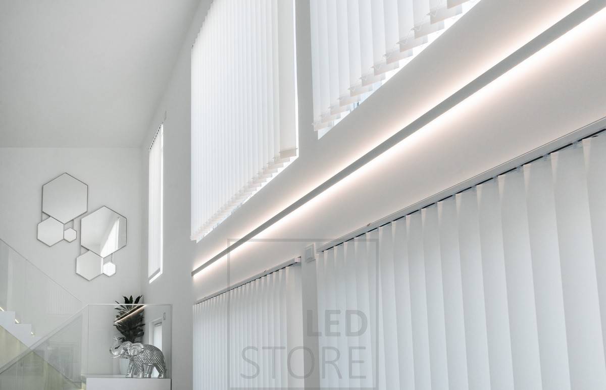 Tira de leds en un perfil de pared bidireccional para enfatizar la altura de la habitación y crear una iluminación ambiental indirecta en el espacio.